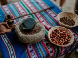 Fresh coffee cherries and a traditional stone grinder at the Lucmabamba coffee farm
