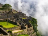 Machu Picchu stone terraces and ruins partially covered in drifting clouds