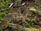 Stone houses and thatched roofs within the Pisac archaeological complex