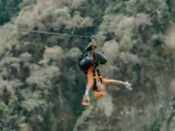 Traveler ziplining upside down through the cloud forest canopy near Santa Teresa