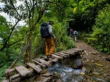 Trekkers crossing a wooden bridge over a mountain stream on the Choquequirao trail