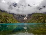 Turquoise Humantay Lake reflecting the glacier and clouds above, Cusco Peru