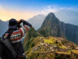 Tourist fotografiert Machu Picchu und den Berg Huayna Picchu zur goldenen Stunde