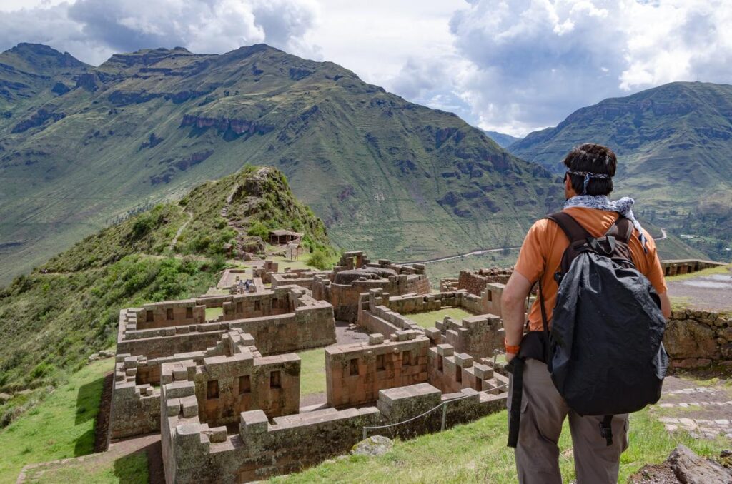 Traveler overlooking the Pisac Inca ruins terraced into the Sacred Valley mountainside