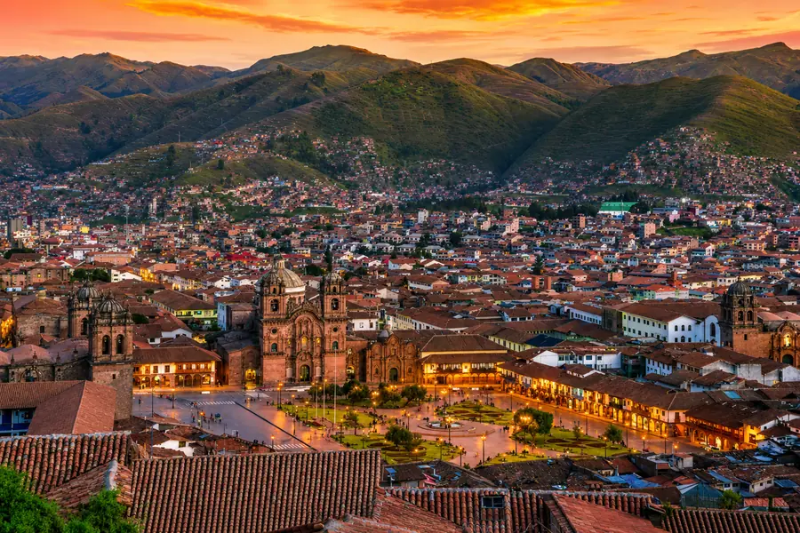 Vista panorâmica do centro histórico de Cusco e da Plaza de Armas ao entardecer.
