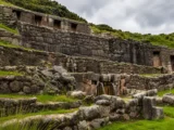 Water running through the stone channels and fountains of Tambomachay, with terraced Inca walls and trapezoidal niches