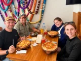 Travelers sharing pizza and drinks at a restaurant during the Inca Jungle Trail
