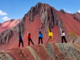 Grupo de viajeros celebrando en la cresta de colores de Pallay Punchu