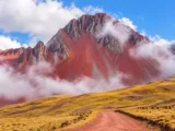 Montaña Pallay Punchu con sus picos rojizos entre las nubes