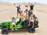 Group posing on a sand buggy atop the dunes of Huacachina in the Ica desert