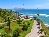 Aerial view of Parque del Amor in Miraflores with paragliders flying over the Lima coastline
