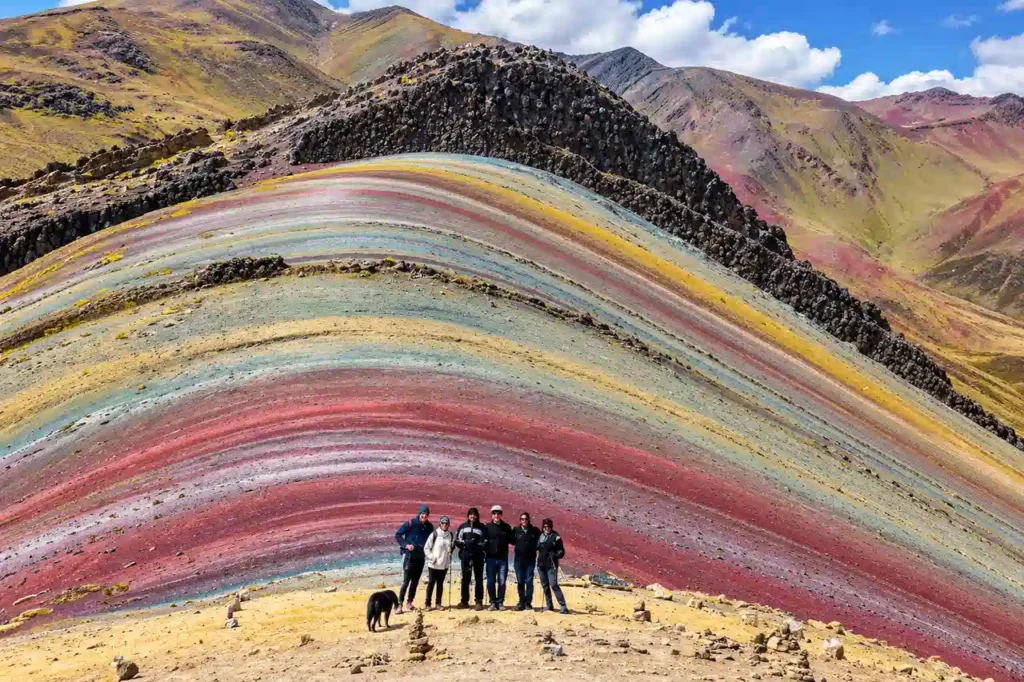 Visitors at the Rainbow Mountain Peru altitude of 5,036 meters, in front of its red, yellow and green mineral stripes