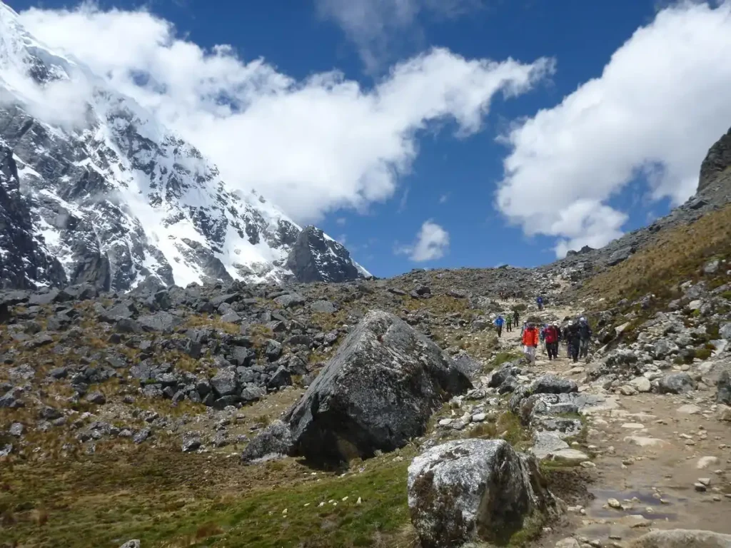 Trilheiros com mochilas de ataque na trilha sob o Nevado Salkantay