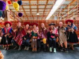 Reisende mit Ponchos bei andinen Weberinnen in Chinchero, Heiliges Tal