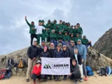 Träger, Köche und Wanderer von Andean Moments mit der Firmenfahne auf dem Inka Trail