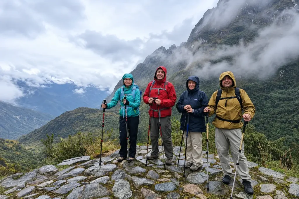 Hikers in rain jackets on an Inca stone path near Machu Picchu