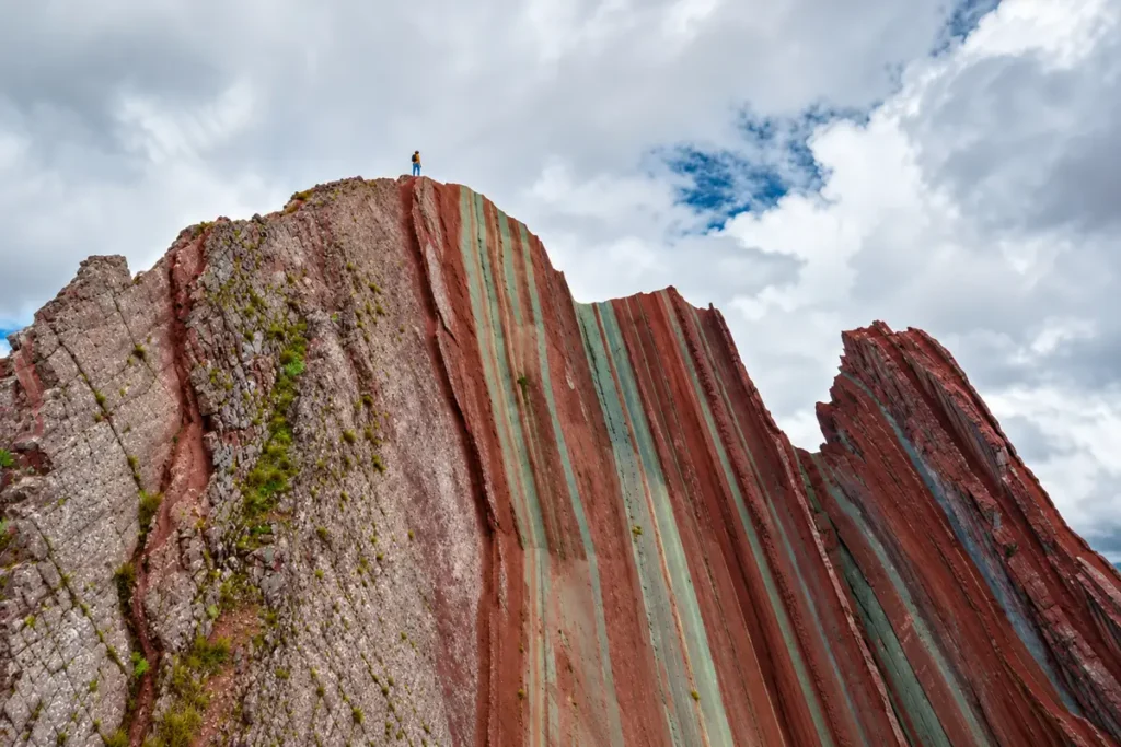 Pallay Punchu, caminante en lo alto del muro de franjas verticales