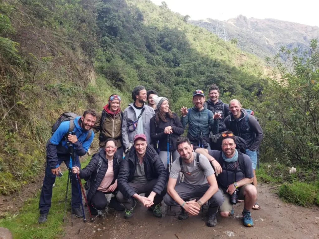 Salkantay hikers in down jackets and beanies with trekking poles in the cloud forest