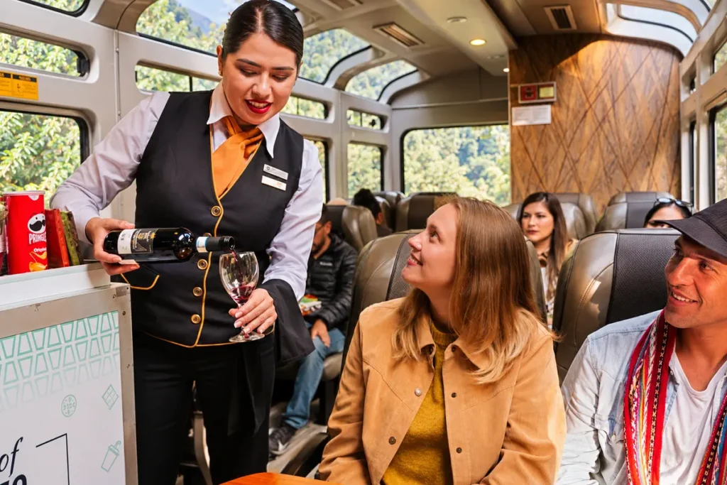 Attendant serving drinks to passengers on the PeruRail Vistadome