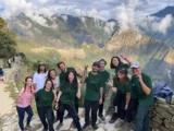 Caminhantes comemorando na Porta do Sol, acima de Machu Picchu, no fim da Trilha Inca