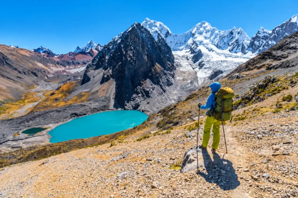 Wanderin über dem See Juraucocha mit dem Siula Grande auf der Huayhuash Runde