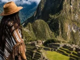 Reisende mit Poncho mit Blick auf die Zitadelle von Machu Picchu und den Huayna Picchu